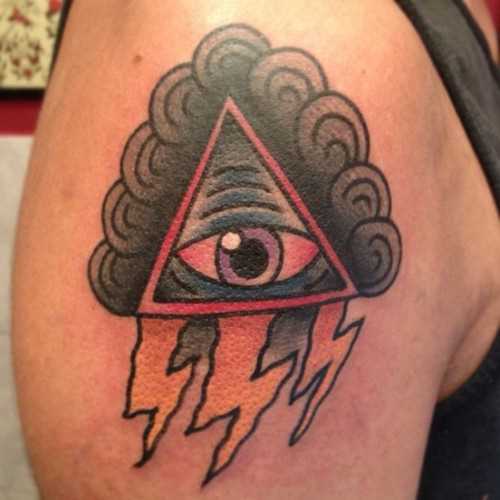 Tatuagem no ombro de um cara - a pirâmide com o olho e o relâmpago