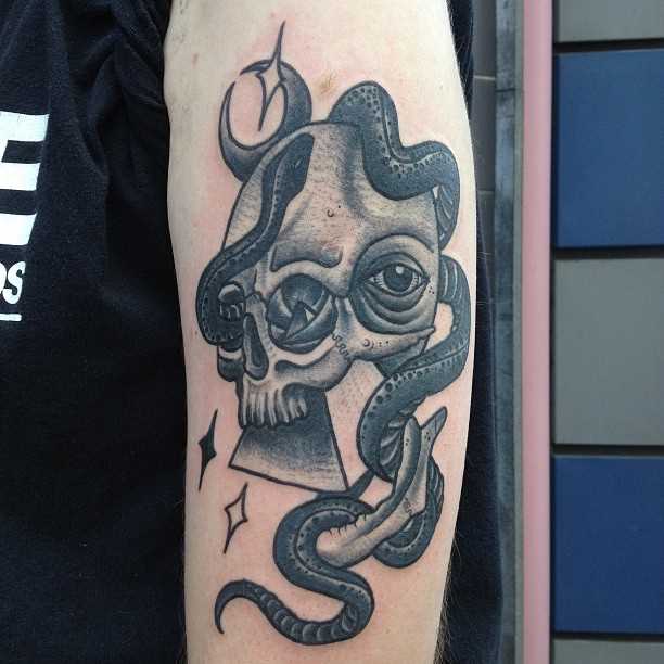 Tatuagem no ombro de um cara - a pirâmide, o crânio e a cobra