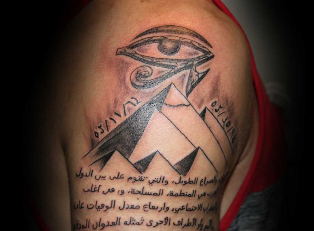 Tatuagem no ombro de um cara - a pirâmide, o olho e a inscrição