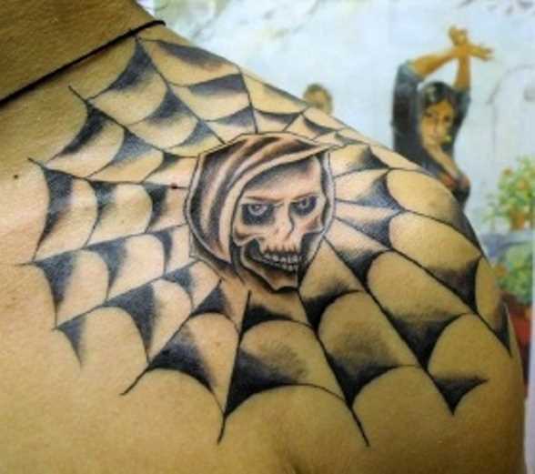 Tatuagem no ombro de um cara - a web e o crânio