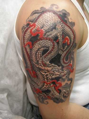 Tatuagem no ombro de um cara com a imagem de um dragão