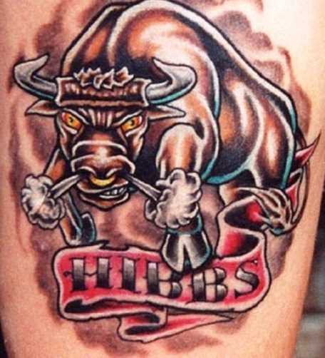 Tatuagem no ombro de um cara com a imagem de um touro e inscrições
