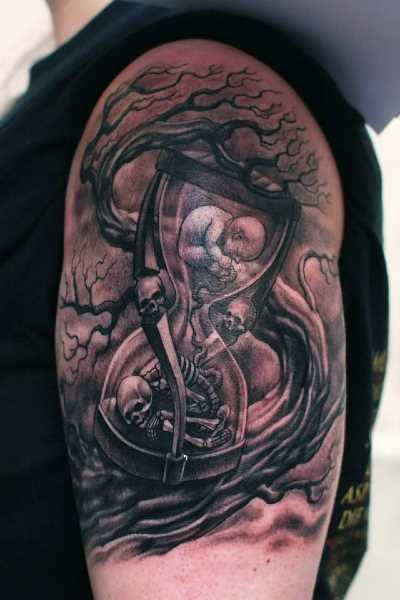 Tatuagem no ombro de um cara - de ampulheta com crânios