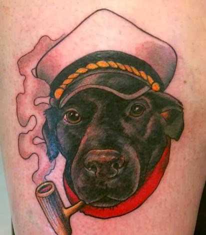 Tatuagem no ombro de um cara - de- cão, com um tubo de