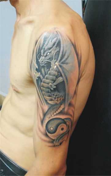 Tatuagem no ombro de um cara de dragão, e o símbolo do Yin-Yang