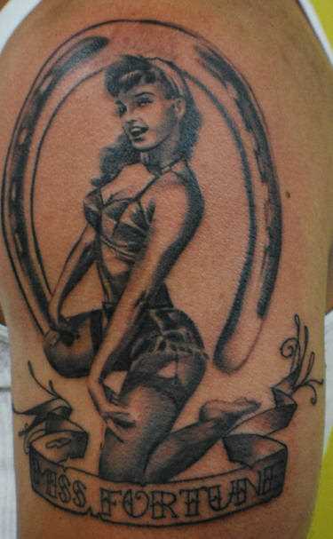 Tatuagem no ombro de um cara - de- ferradura, a menina e a inscrição