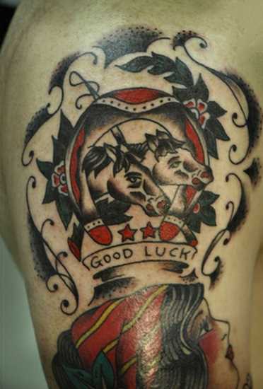 Tatuagem no ombro de um cara - de- ferradura e dois cavalos