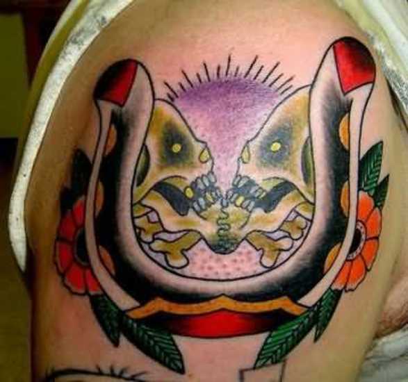 Tatuagem no ombro de um cara - de- ferradura e dois crânios