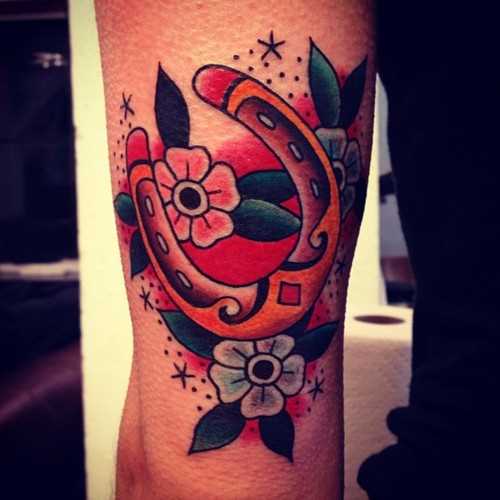 Tatuagem no ombro de um cara - de- ferradura e flores