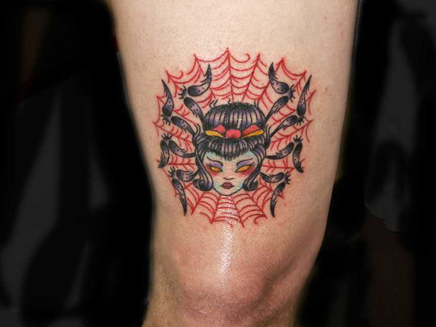 Tatuagem no ombro de um cara - de- teia de aranha e a aranha com a cabeça da menina