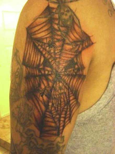 Tatuagem no ombro de um cara - de- teia de aranha na forma de um crânio e aranhas