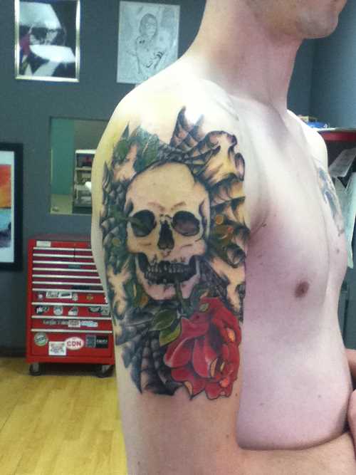 Tatuagem no ombro de um cara - de- teia de aranha, o crânio e a rosa
