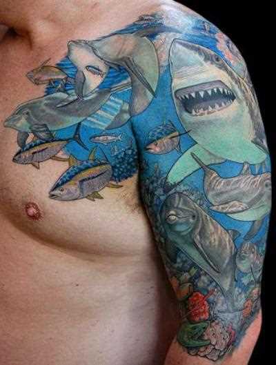 Tatuagem no ombro de um cara - de tubarão e golfinhos