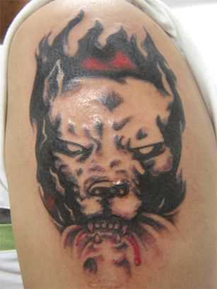 Tatuagem no ombro de um cara em forma de cães com raiva