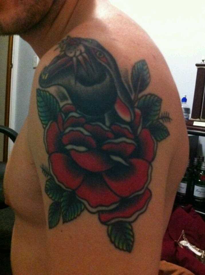 Tatuagem no ombro de um cara em forma de pantera e rosas