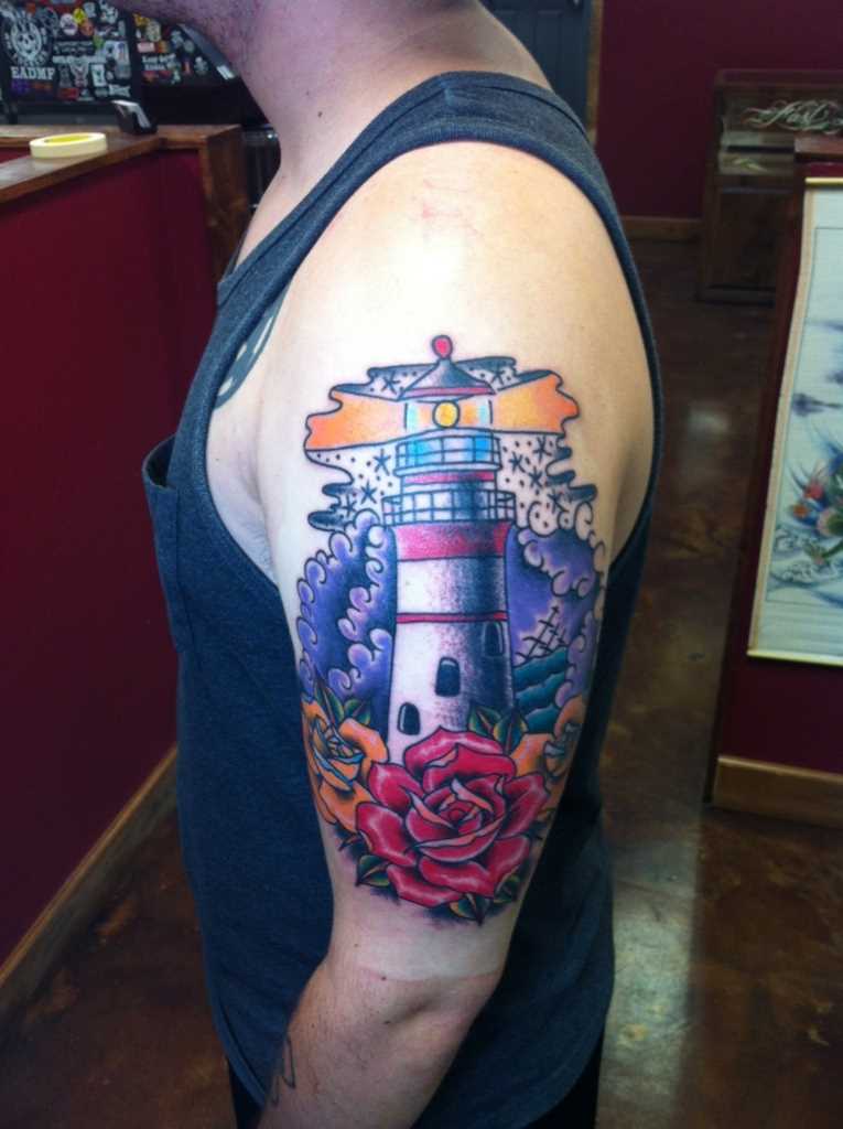 Tatuagem no ombro de um cara - farol e rosas