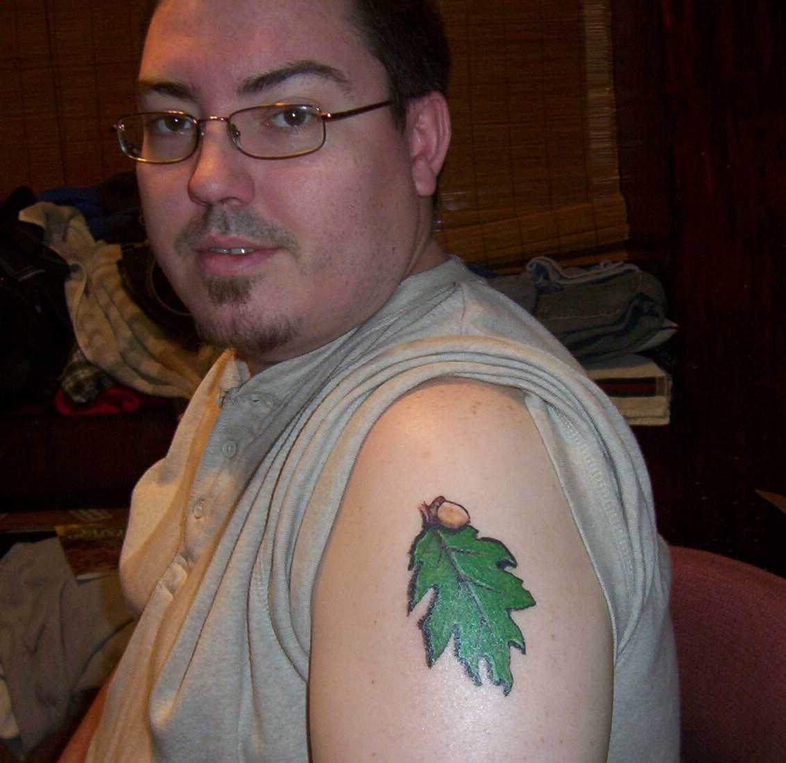 Tatuagem no ombro de um cara - folha verde