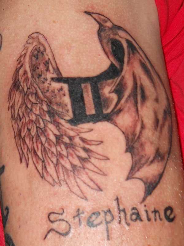 Tatuagem no ombro de um cara - signo de gêmeos. as asas e a inscrição