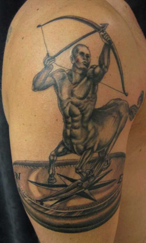 Tatuagem no ombro de um cara - signo de sagitário e uma bússola
