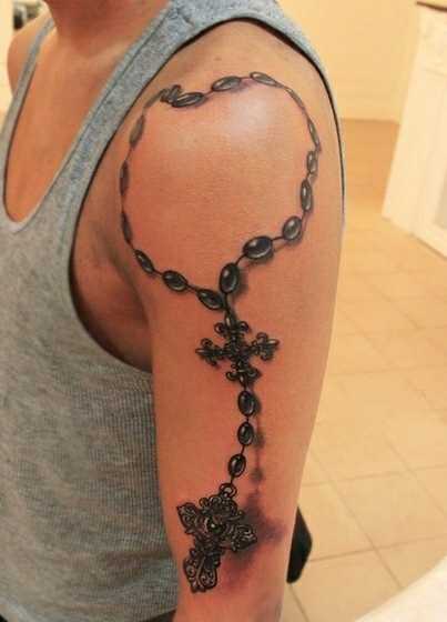 Tatuagem no ombro de um cara - um colar com cruzes