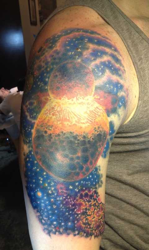 Tatuagem no ombro do cara - o espaço e o planeta