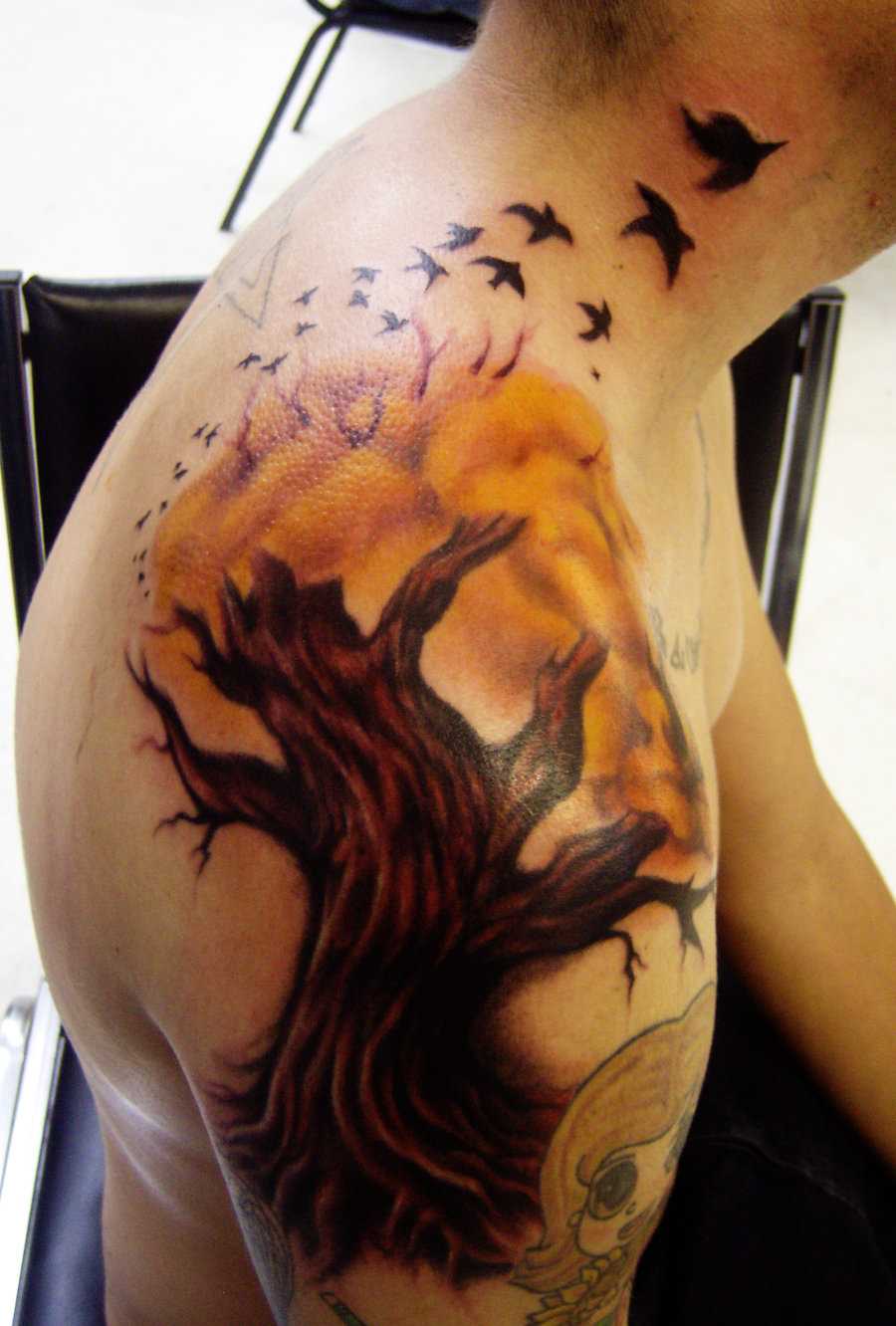 Tatuagem no ombro o homem - árvore, e as aves