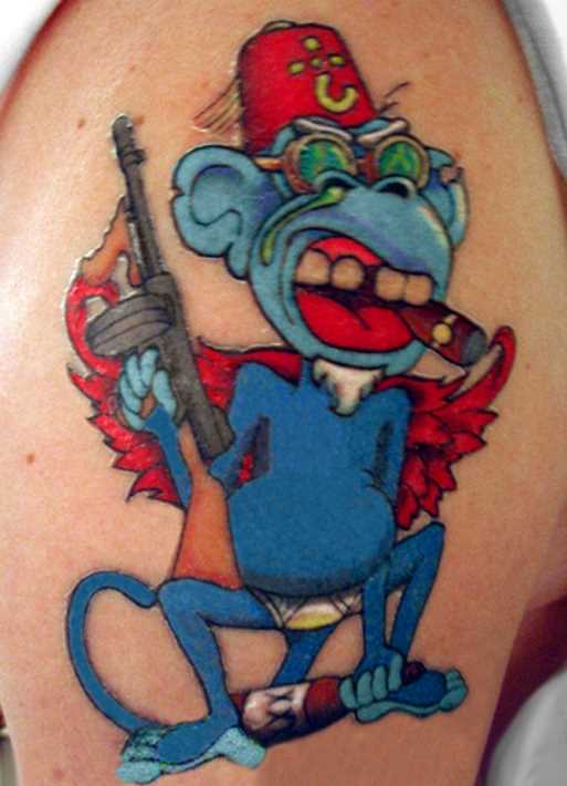 Tatuagem no ombro o homem - macaco com uma arma