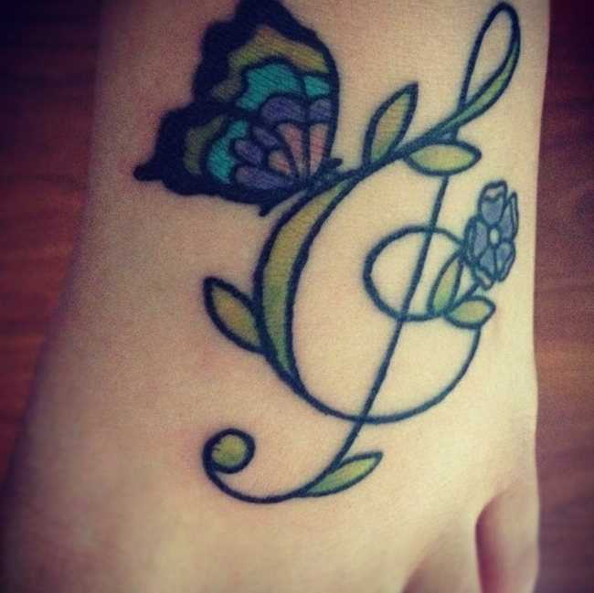 Tatuagem no pé da menina - clave de sol, a borboleta e a flor