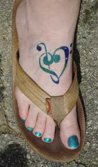 Tatuagem no pé da menina - clave de sol e notas