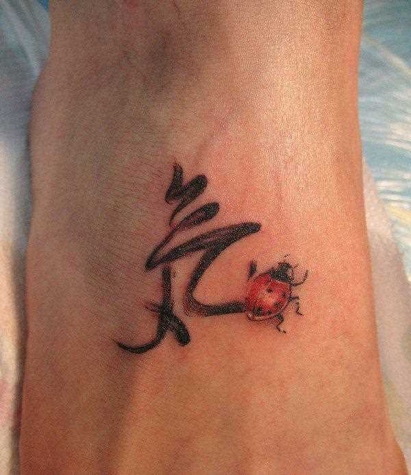 Tatuagem no pé da menina - joaninha e o hieróglifo