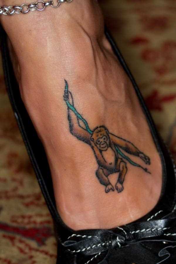 Tatuagem no pé da menina - macaco no galho