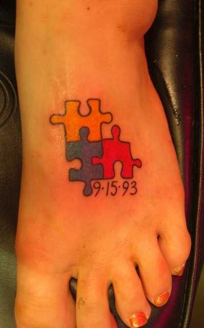 Tatuagem no pé de uma menina de quebra - cabeças e uma inscrição em forma de data