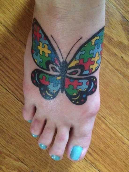 Tatuagem no pé de uma menina de quebra - cabeças em forma de borboleta