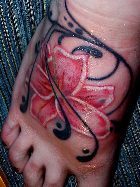 Tatuagem no pé de uma menina em forma de lírios cor-de-rosa