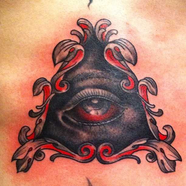 Tatuagem no peito da menina - a pirâmide com o olho
