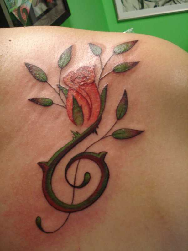 Tatuagem no peito da menina - clave de sol e rosa