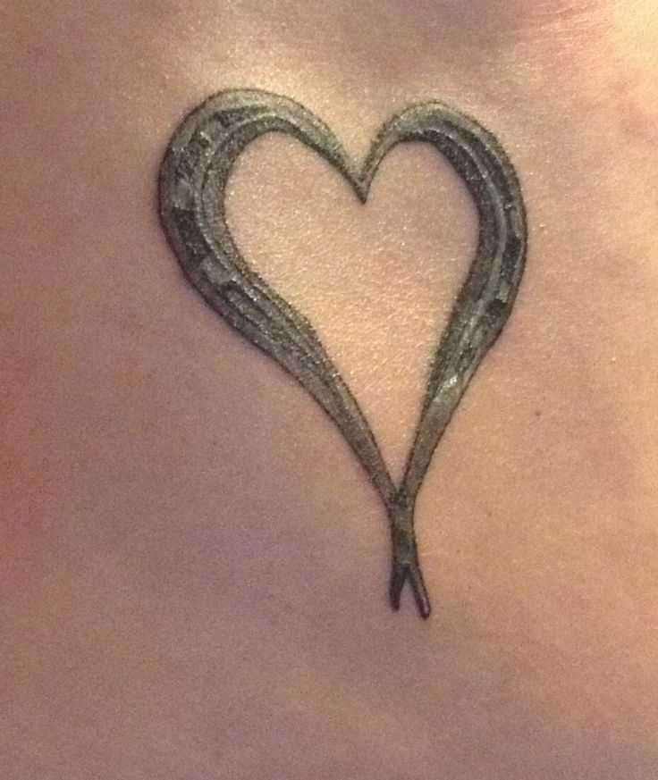 Tatuagem no peito da menina - ferradura em forma de coração