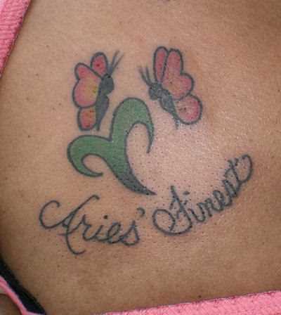 Tatuagem no peito da menina - signo de áries, borboletas e inscrição