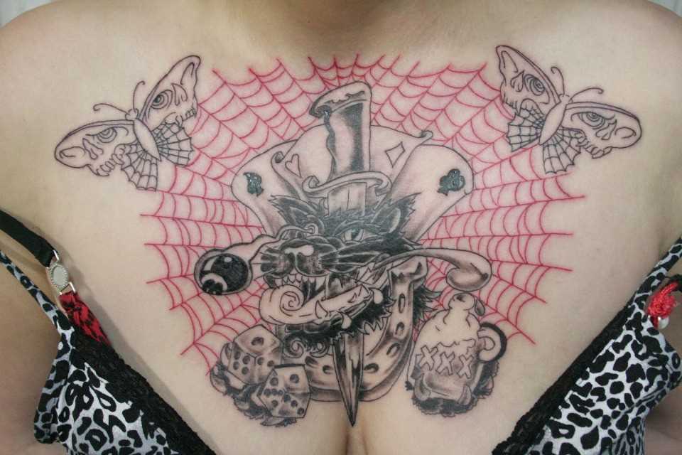 Tatuagem no peito da menina - teia de aranha, um cartão, um punhal, o dado, a ferradura e as borboletas