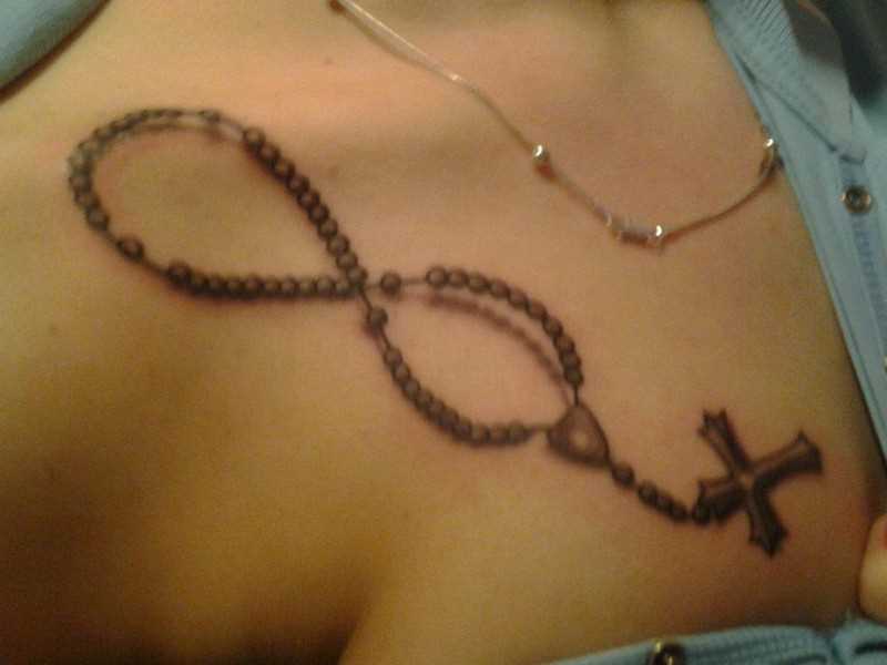 Tatuagem no peito da menina - um colar com uma cruz