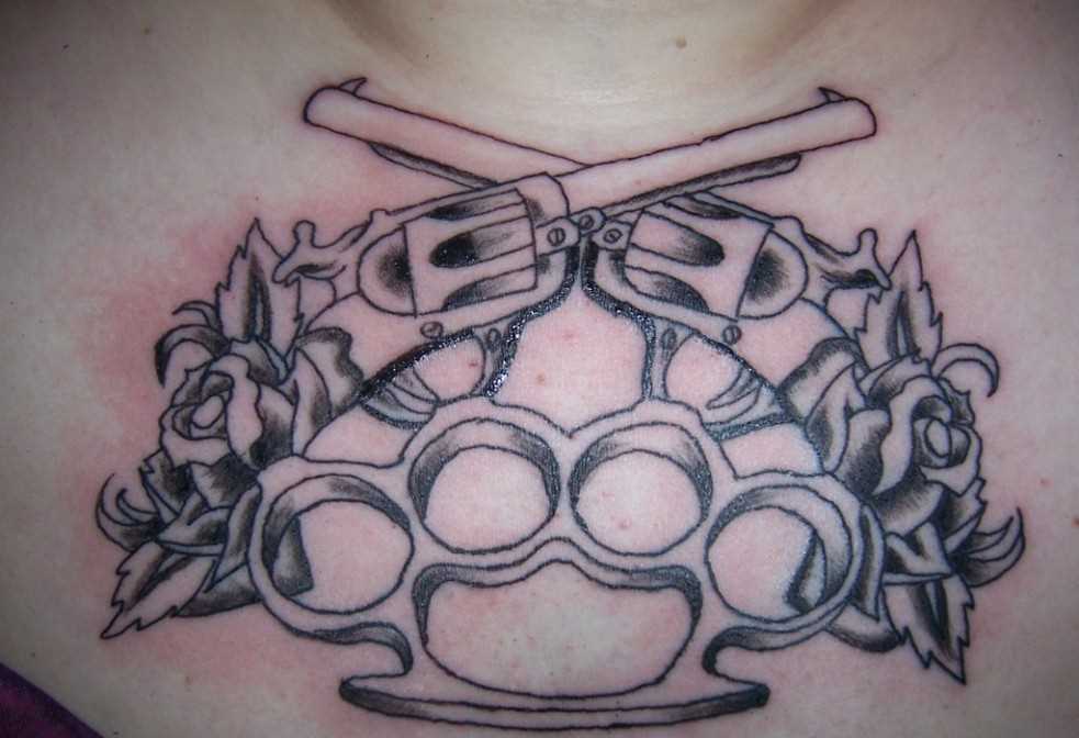 Tatuagem no peito da menina - uma pistola, kostet e rosas