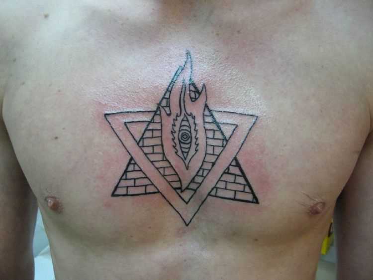 Tatuagem no peito de um cara - a pirâmide com o olho e o fogo