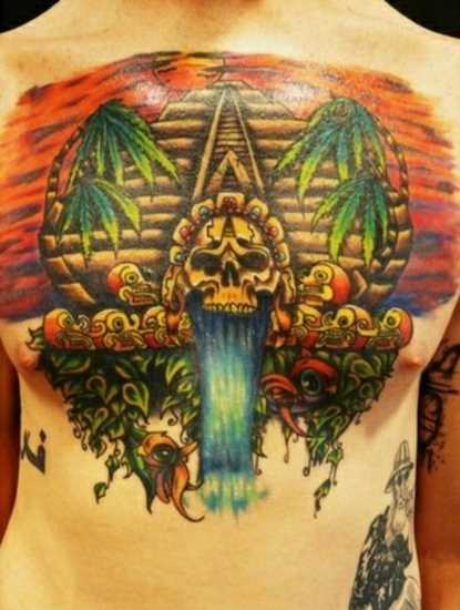 Tatuagem no peito de um cara - a pirâmide, o crânio e palmeiras