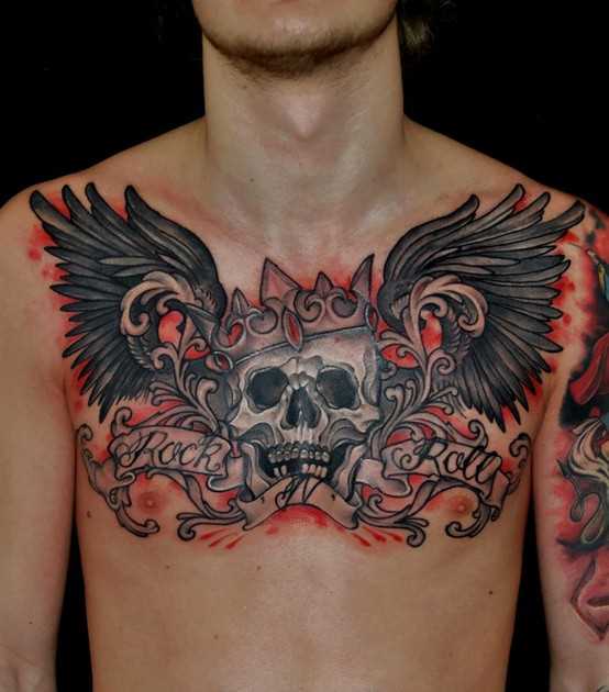 Tatuagem no peito de um cara - de- asas, a coroa, crânio e legenda em inglês