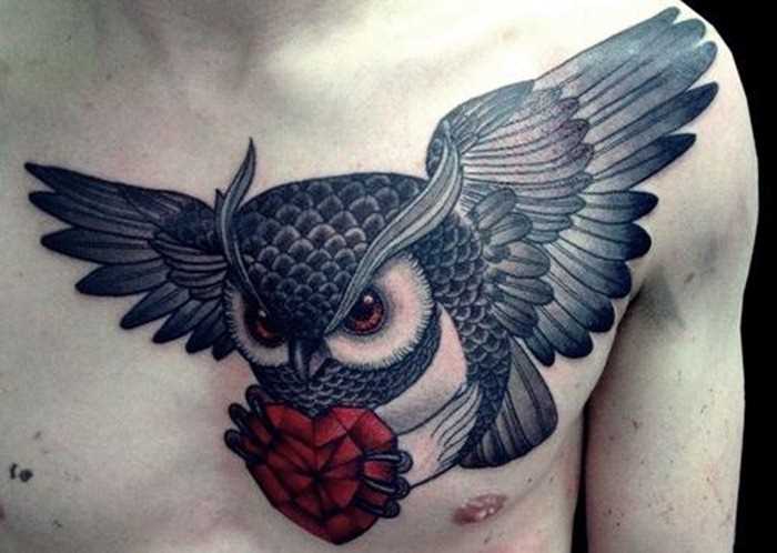 Tatuagem no peito de um cara - de- coruja com o coração nas garras