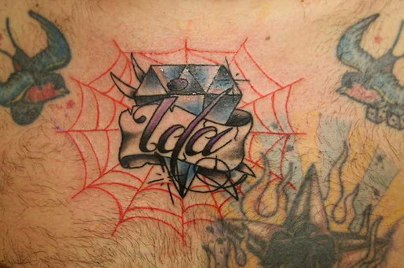 Tatuagem no peito de um cara - de- teia de aranha, diamante e inscrição