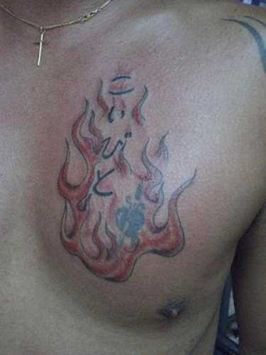 Tatuagem no peito de um cara em forma de fogo, e o coração com punhal