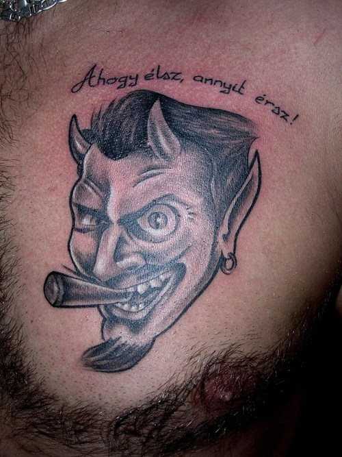 Tatuagem no peito do homem - o diabo com a inscrição