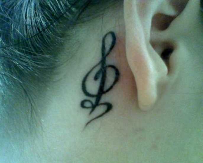 Tatuagem no pescoço de uma menina atrás da orelha - clave de sol