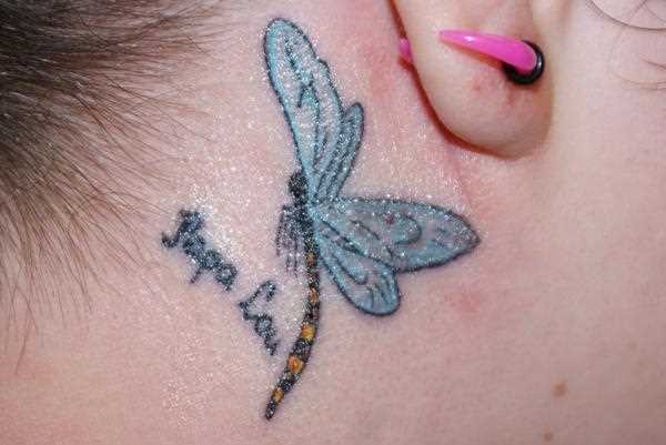 Tatuagem no pescoço de uma menina atrás da orelha - libélula